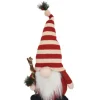 GNOME PLUSH STANDING WITH RED/WHITE STRIPES HAT HOLDING PINE AND BERRY 16″H